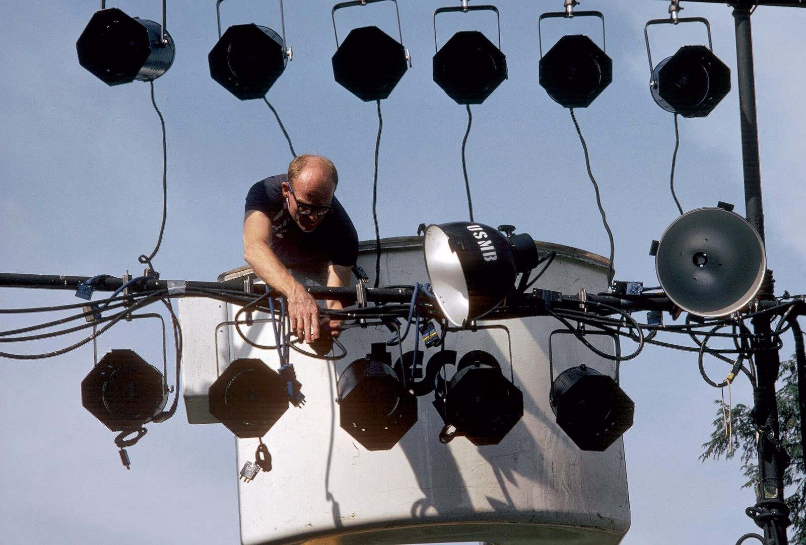A member of the stage crew makes adjustments on lights for the US Navy Band's Silver Anniversary Lollipop Concert - DPLA - bba9273ee2b50d2a53595243a16342a9